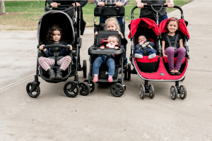 Children sitting in double strollers