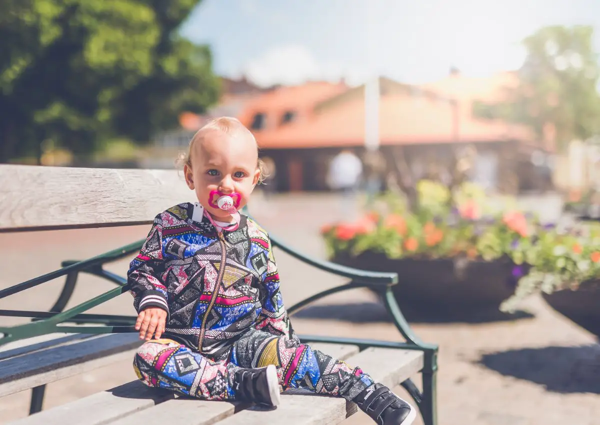 boy sitting on a bench with a pacifier