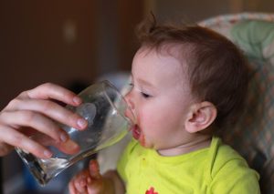 baby drinking water from a glass