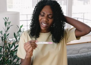 woman confused reading pregnancy test